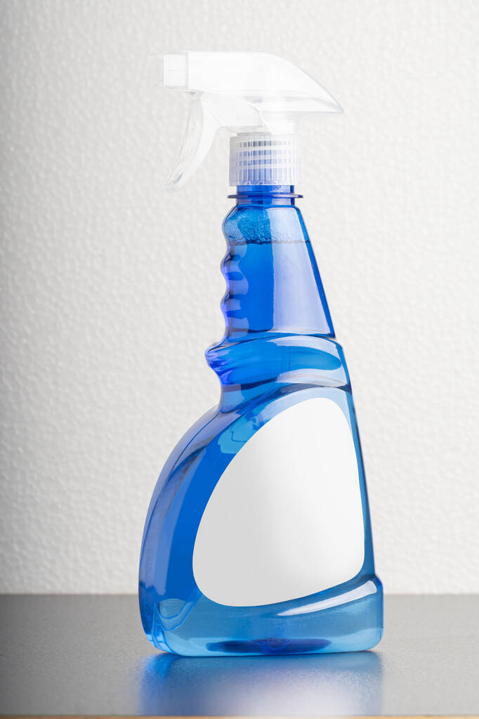 Μια κάθετη λήψη του cCleaning μπουκάλι υγρό σε ανοιχτό γκρι φόντο - Φωτογραφία, εικόνα