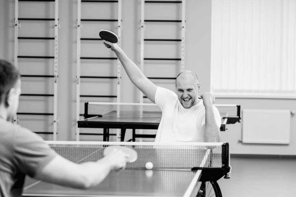 Uomini disabili adulti in sedia a rotelle che giocano a ping pong - Foto, immagini