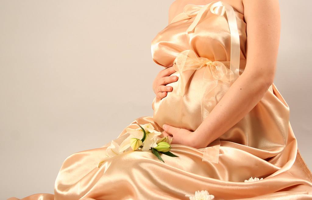 güzel bir hamile kadın altın ipek sarılmış - Fotoğraf, Görsel