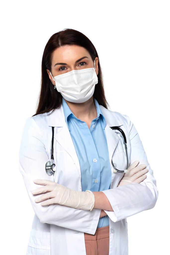Arzt in Latexhandschuhen und medizinischer Maske stehend mit verschränkten Armen isoliert auf weiß  - Foto, Bild