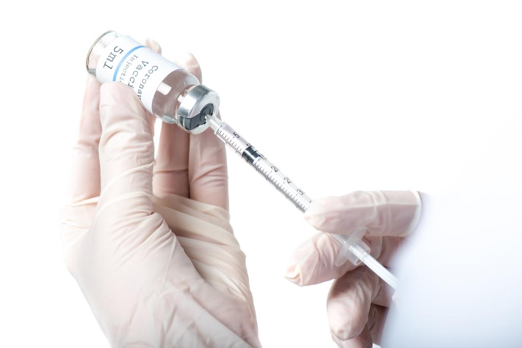 Widok lekarza odbierającego szczepionkę w strzykawce wyizolowanej na biało  - Zdjęcie, obraz