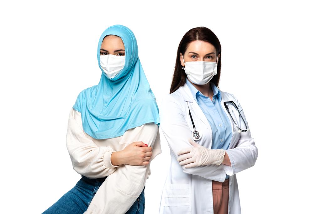 paziente musulmano in piedi vicino al medico in maschera medica isolato su bianco  - Foto, immagini