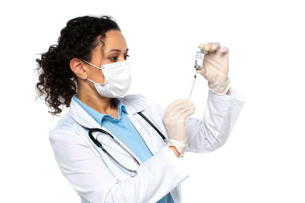 アフリカ系アメリカ人の医師が白色に隔離された注射器でワクチンを拾う  - 写真・画像