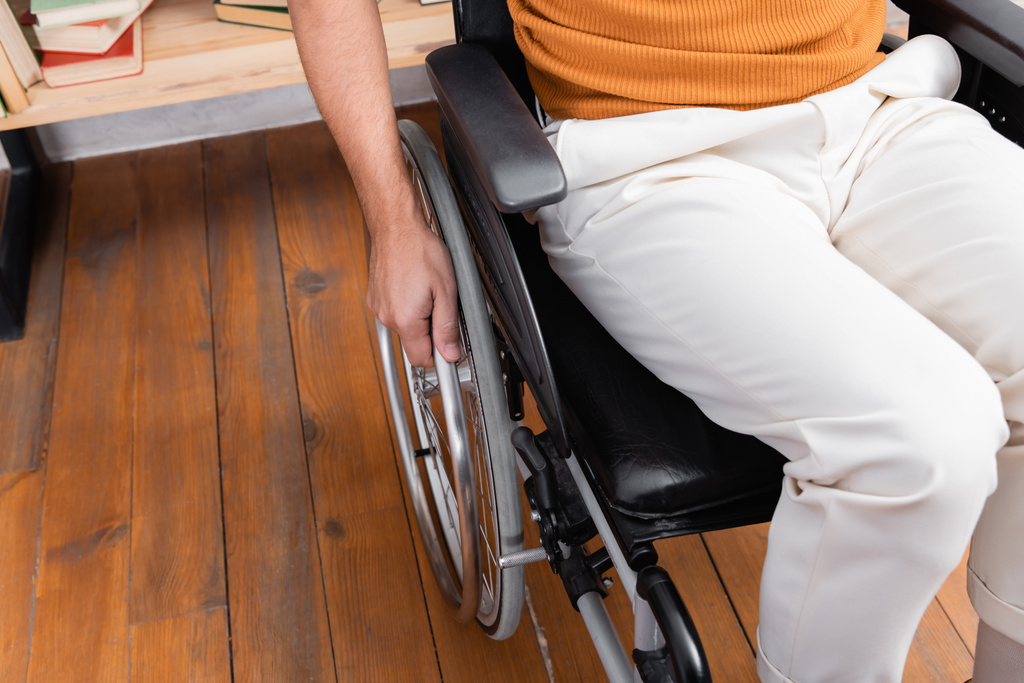обрізаний вид інваліда сидить у інвалідному візку вдома
 - Фото, зображення