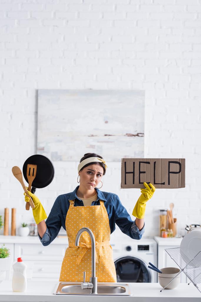 Сумна домогосподарка тримає плакат за допомогою малювання та посуду на кухні
  - Фото, зображення