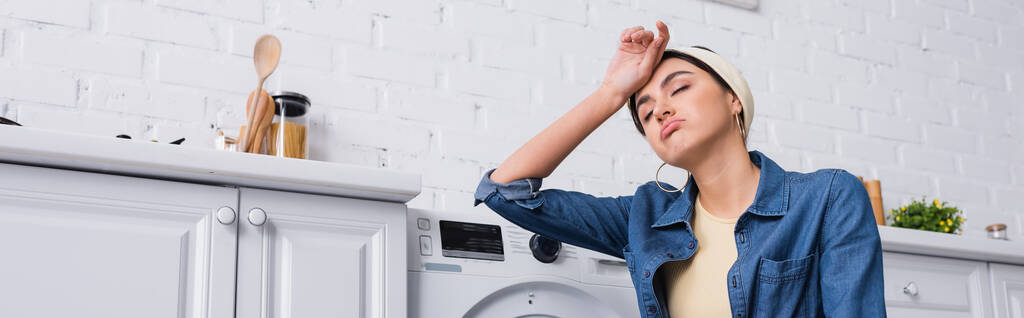 Уставшая женщина возле стиральной машины на кухне, баннер  - Фото, изображение