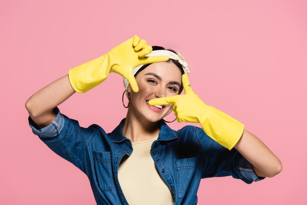Cheerful woman in rubber gloves looking at camera isolated on pink - Photo, Image