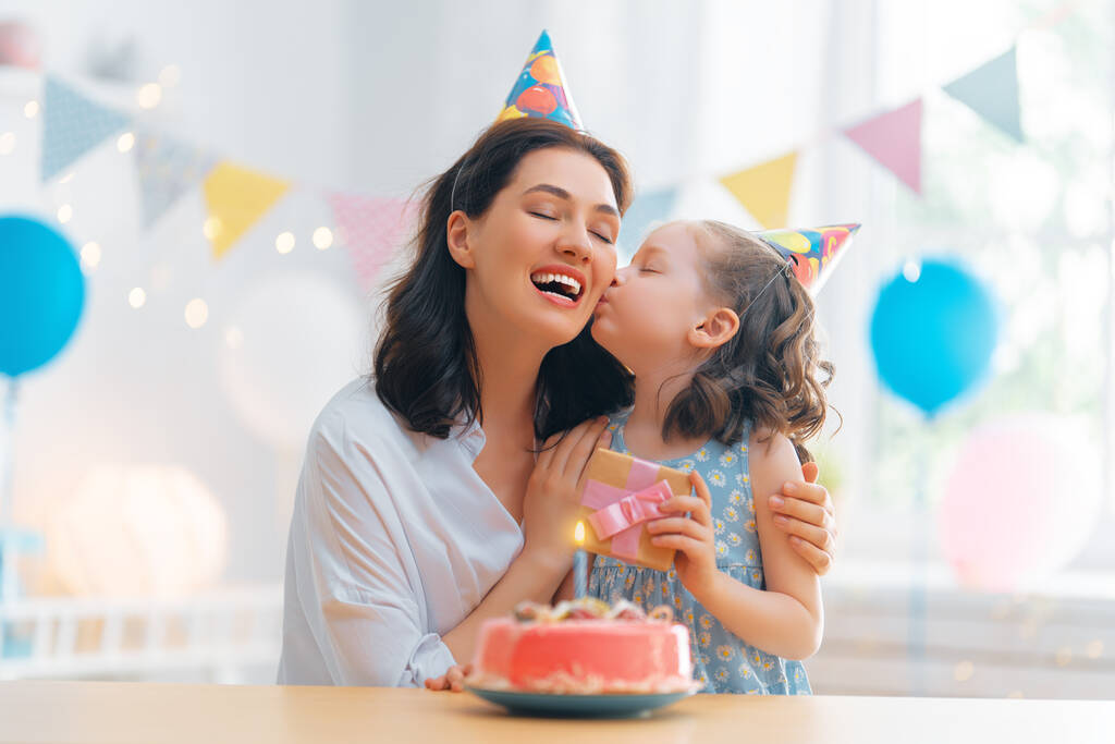 Le gamin souffle les bougies sur le gâteau. Mère et fille fêtent leur anniversaire. - Photo, image