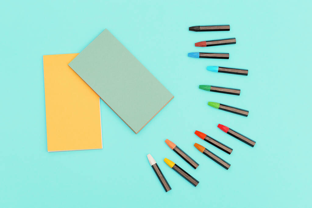 Visão superior de lápis de cor pastel e notebook na primavera para esboços. Conjunto de giz multicoloridos para a criatividade. Espaço de trabalho para desenho. - Foto, Imagem