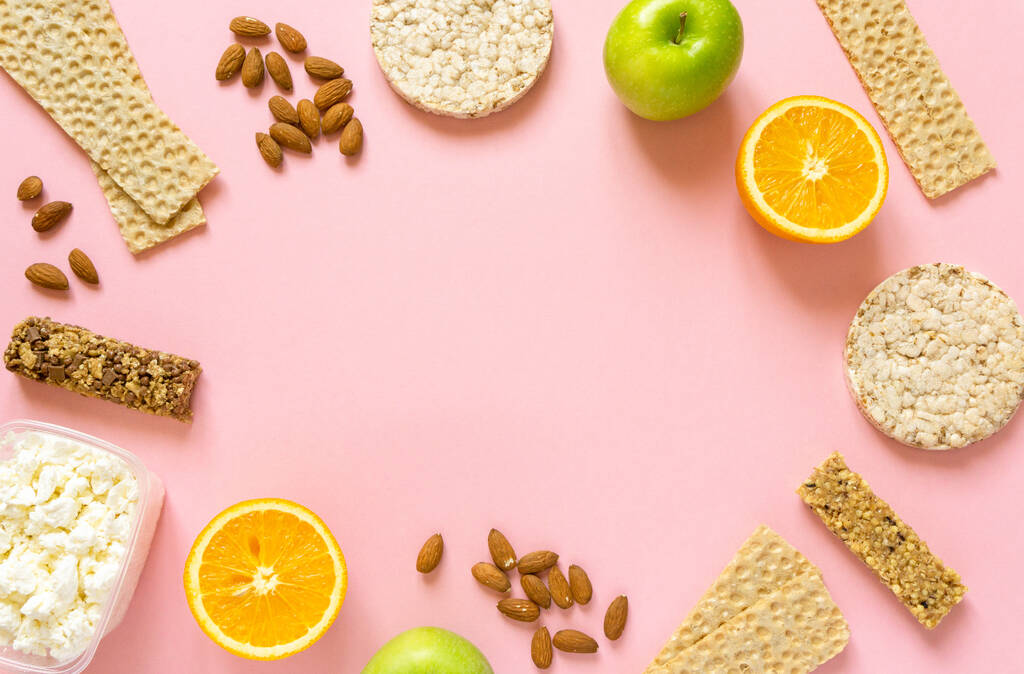 Frame of various healthy snacks on pink background, space for text - Photo, Image