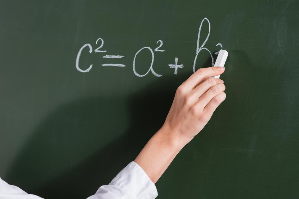 Cropped view of teacher writing equation on chalkboard  - Photo, Image