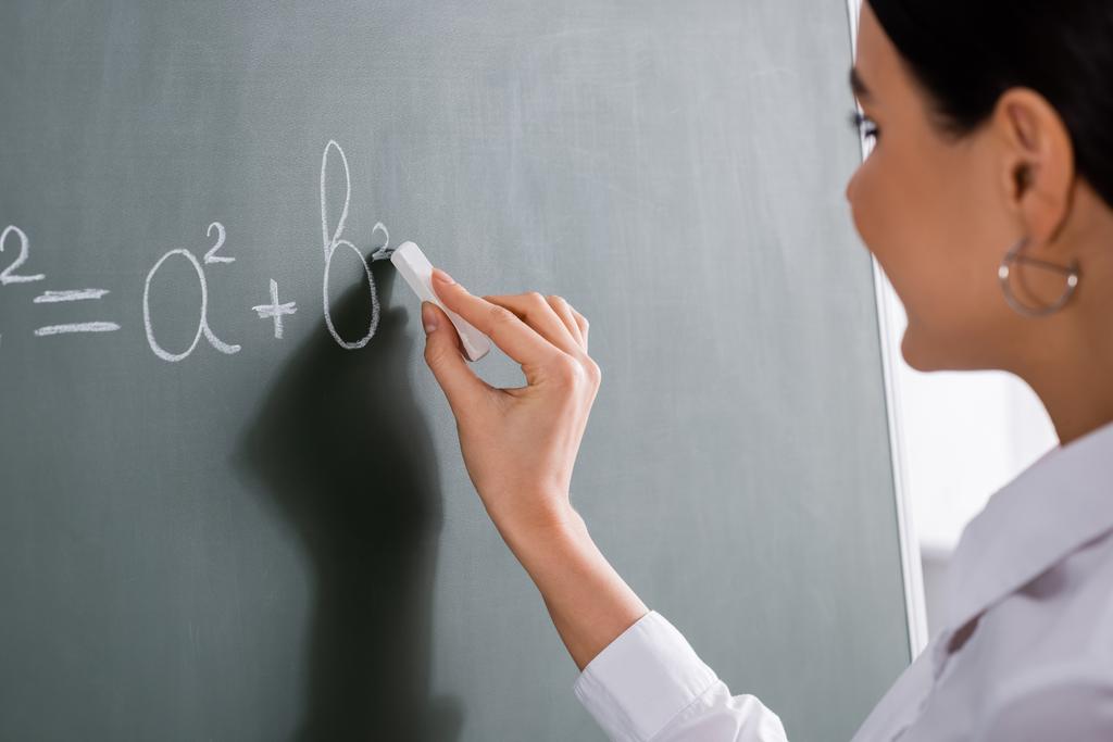 Homályos tanár matematikai képletet ír a táblára  - Fotó, kép