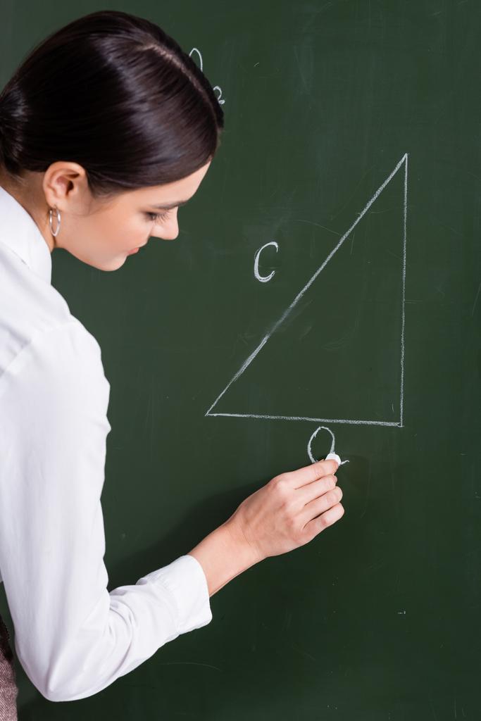 Tanár írás háromszög táblán az osztályteremben  - Fotó, kép