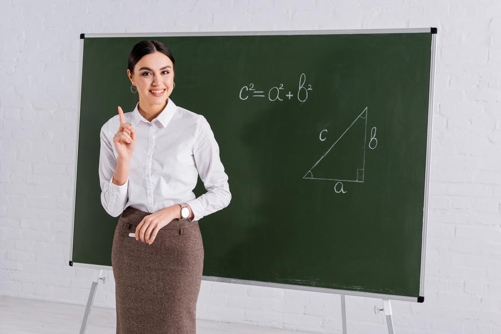 Positiivinen opettaja osoittaa sormella aikana matemaattinen oppitunti koulussa  - Valokuva, kuva