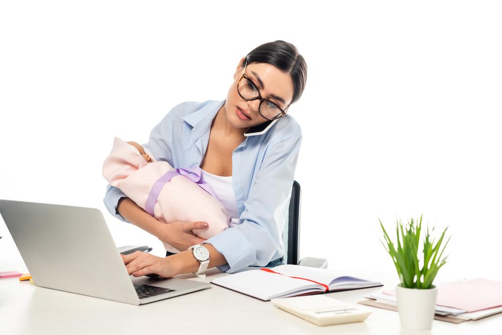 joven hombre de negocios escribiendo en el ordenador portátil mientras sostiene bebé bebé aislado en blanco - Foto, Imagen