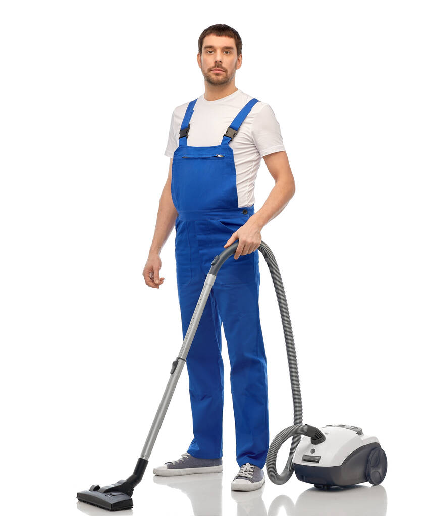 male worker cleaning floor with vacuum cleaner - Photo, Image
