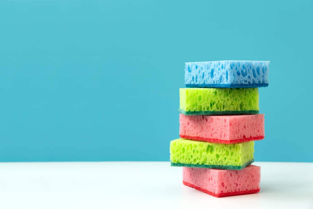 Stack of kitchen cleaning sponges on blue background. Front view - Fotoğraf, Görsel
