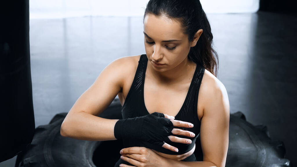 jovem morena esportista colocando em mãos bandagens de boxe - Foto, Imagem