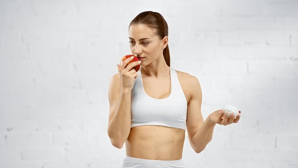 Sportsmenka pachnąca jabłkiem i trzymająca piankę - Zdjęcie, obraz