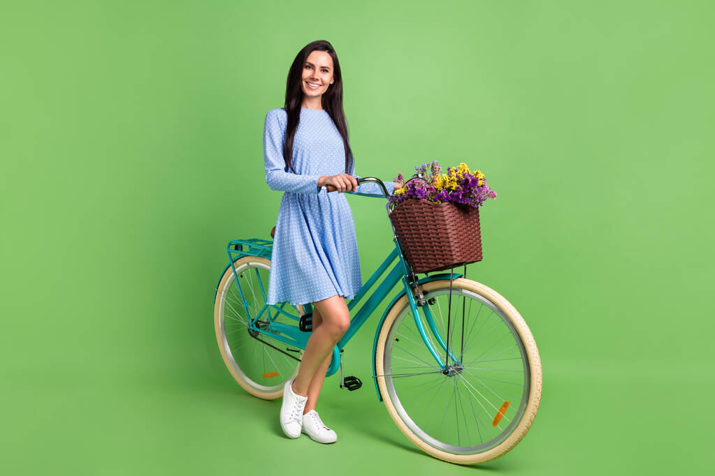 Pełna długość profil zdjęcie słodkie brązowe włosy pani z sukienka strój rowerowy izolowane na zielonym tle - Zdjęcie, obraz