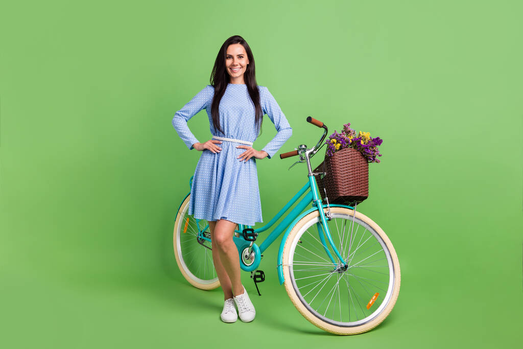 Pleine photo du corps de dame mignonne tendance cheveux bruns près de vélo porter robe isolé sur fond vert - Photo, image