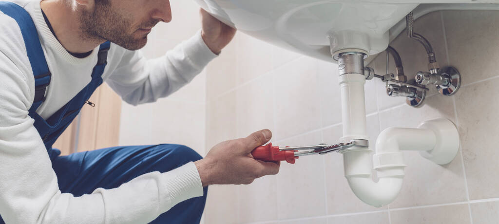 Professionele loodgieter installeren of bevestigen van een wastafel thuis - Foto, afbeelding
