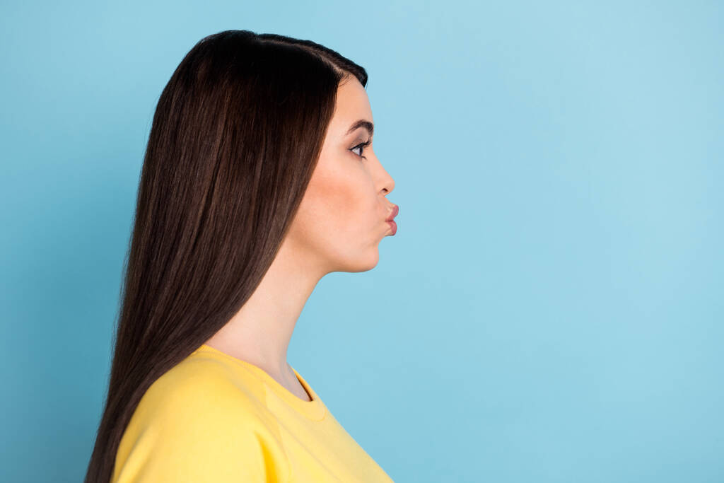 Profile photo of adorable romantic lady send air kiss look empty space wear yellow jumper isolated blue background - Photo, Image