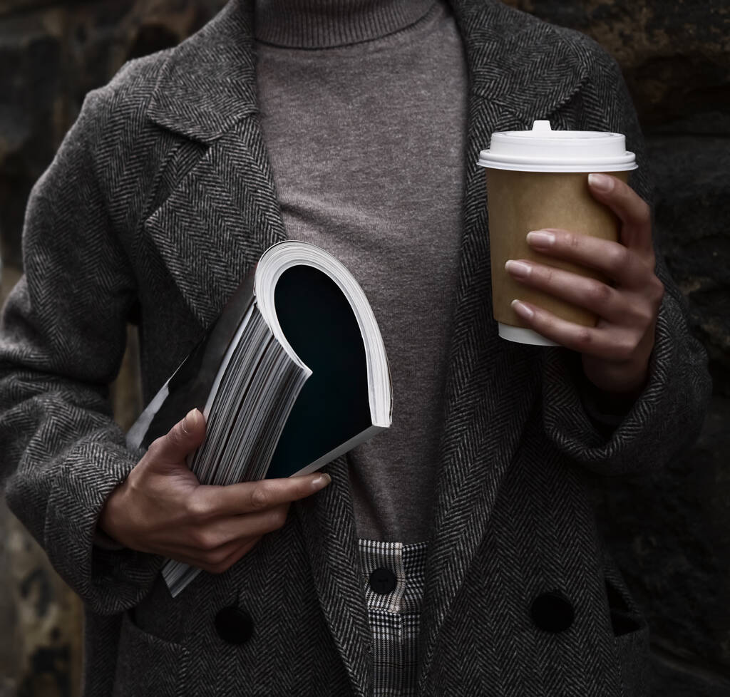 Mulher de moda usando casaco, segurando na mão revista de moda e xícara de café. sem rosto.  - Foto, Imagem