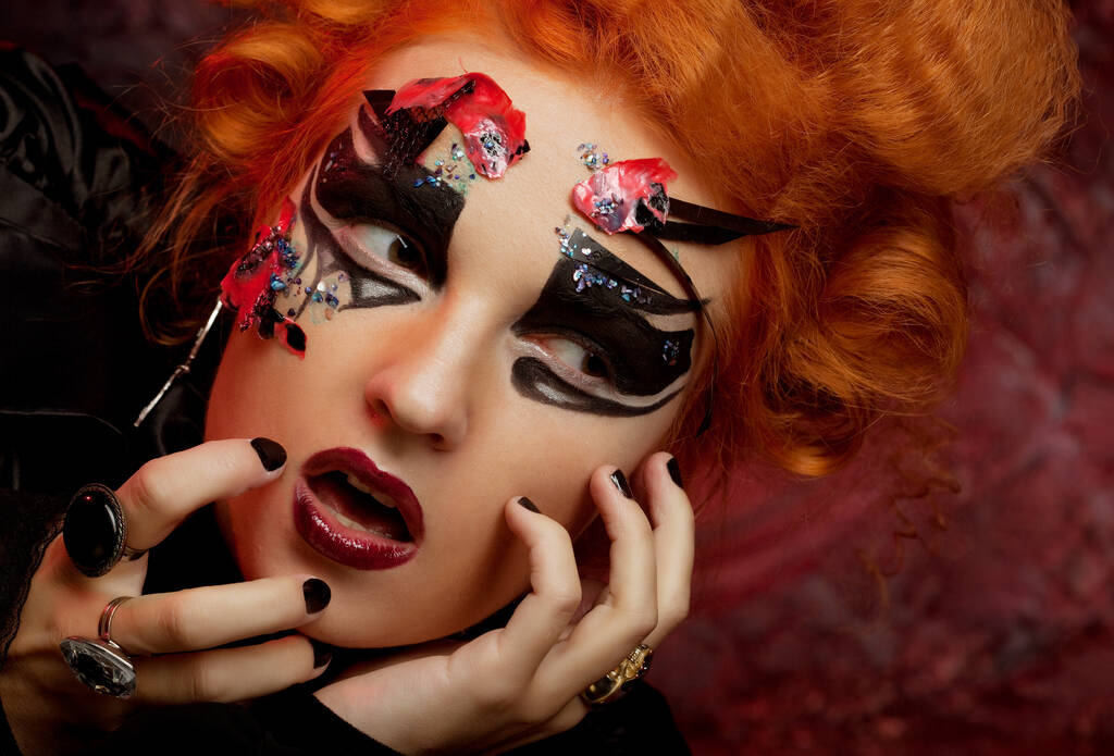 Rudowłosa młoda kobieta w kostiumie czarownicy. Kreatywny makijaż do maskarady. - Zdjęcie, obraz
