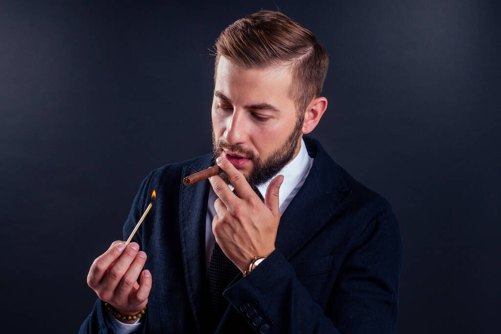 Ritratto di un uomo d'affari attraente con un sigaro in studio di sfondo nero - Foto, immagini