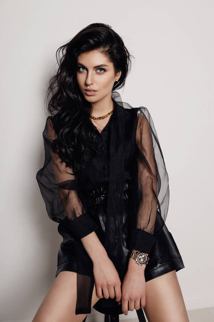 foto de moda de mujer hermosa con el pelo oscuro en vestido elegante y accesorios posando en el estudio - Foto, Imagen