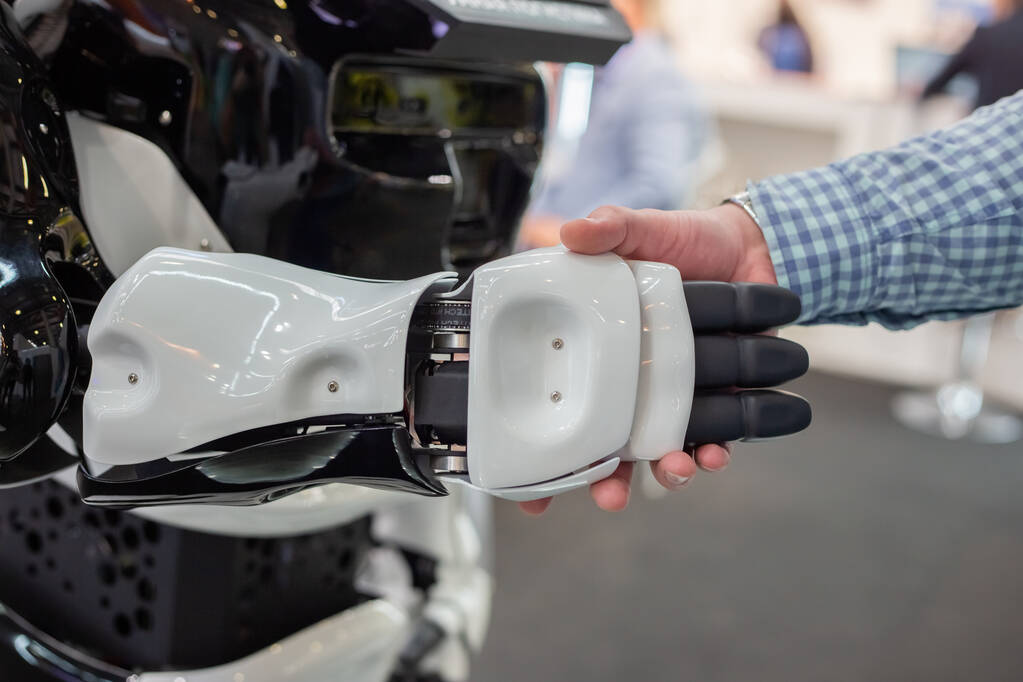 Moscou, Russie - 14 avril 2021 : Un visiteur de l'exposition serre la main d'un robot intelligent à l'un des stands de l'exposition internationale des services de transport et de logistique - Photo, image