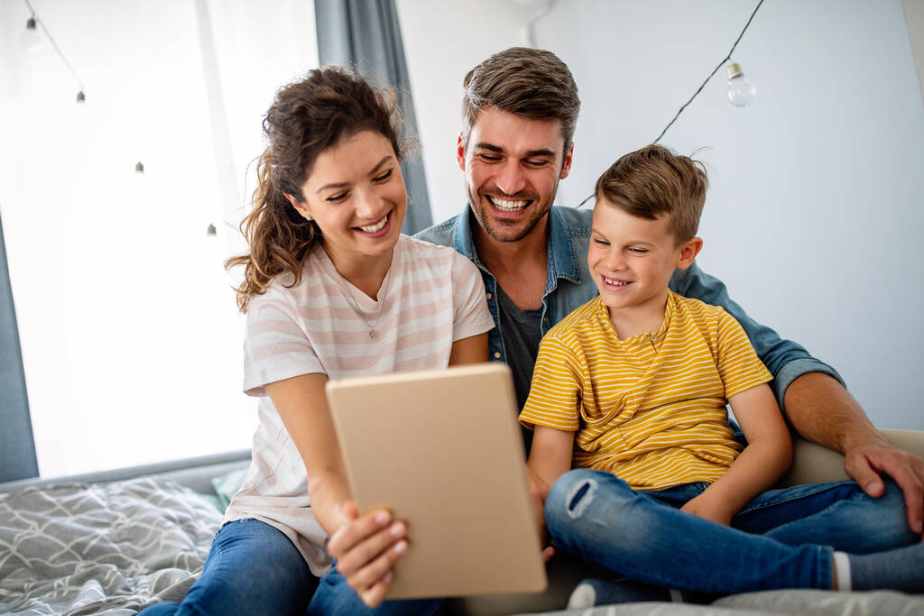 Šťastná rodina používající technologie společně doma. Lidé, koncepce vzdělávání. - Fotografie, Obrázek