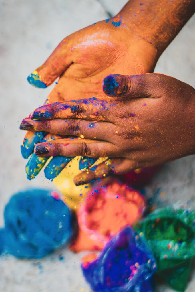 Een verticaal shot van vrouwelijke handen in kleurrijke verf - Foto, afbeelding