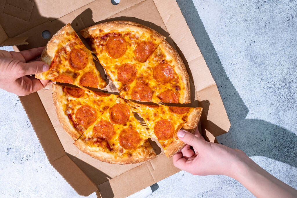La gente toma las manos rodajas de pizza de pepperoni. - Foto, Imagen