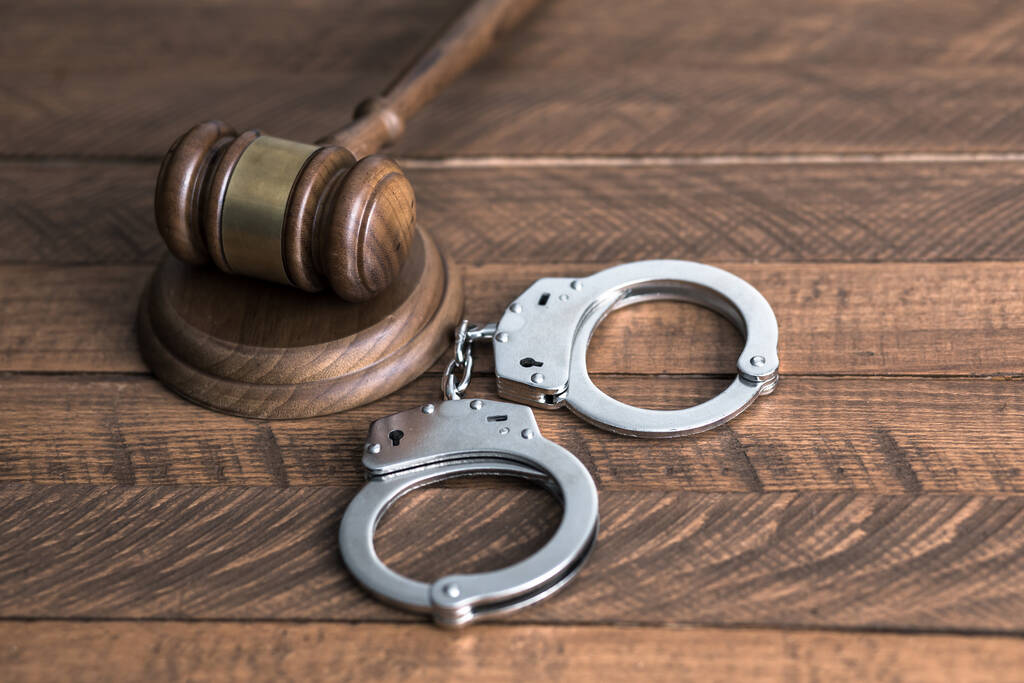 наручники с молотком судьи на деревянной доске - Фото, изображение