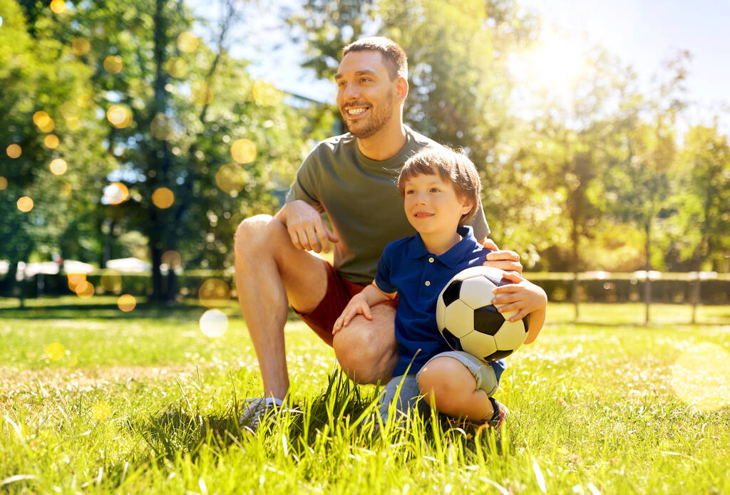 батько і маленький син з футбольним м'ячем у парку
 - Фото, зображення