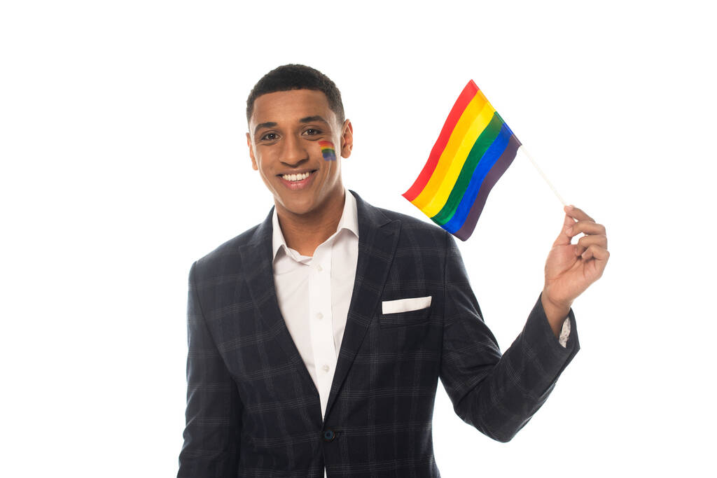 young african american businessman smiling at camera while holding lgbt flag isolated on white - Photo, Image