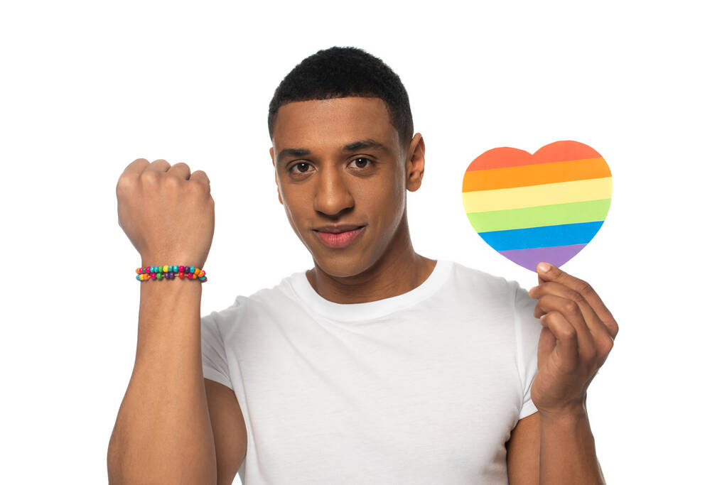 african american man showing beads bracelet and paper heart in lgbt colors isolated on white - Photo, Image