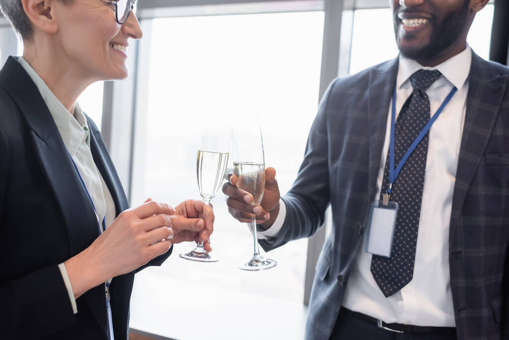 úspěšní obchodní partneři cinkající sklenice šampaňského během obchodního kongresu - Fotografie, Obrázek