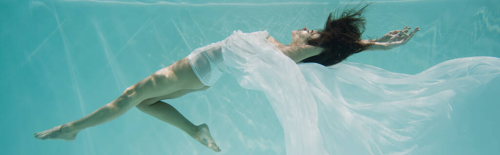 χαριτωμένη νεαρή γυναίκα με λευκό φόρεμα που κολυμπά στην πισίνα, λάβαρο  - Φωτογραφία, εικόνα