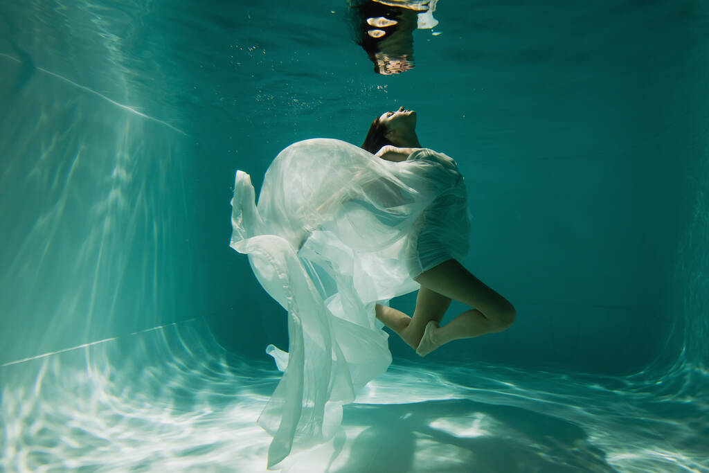 jovem pacífica em branco elegante vestido de natação na piscina  - Foto, Imagem