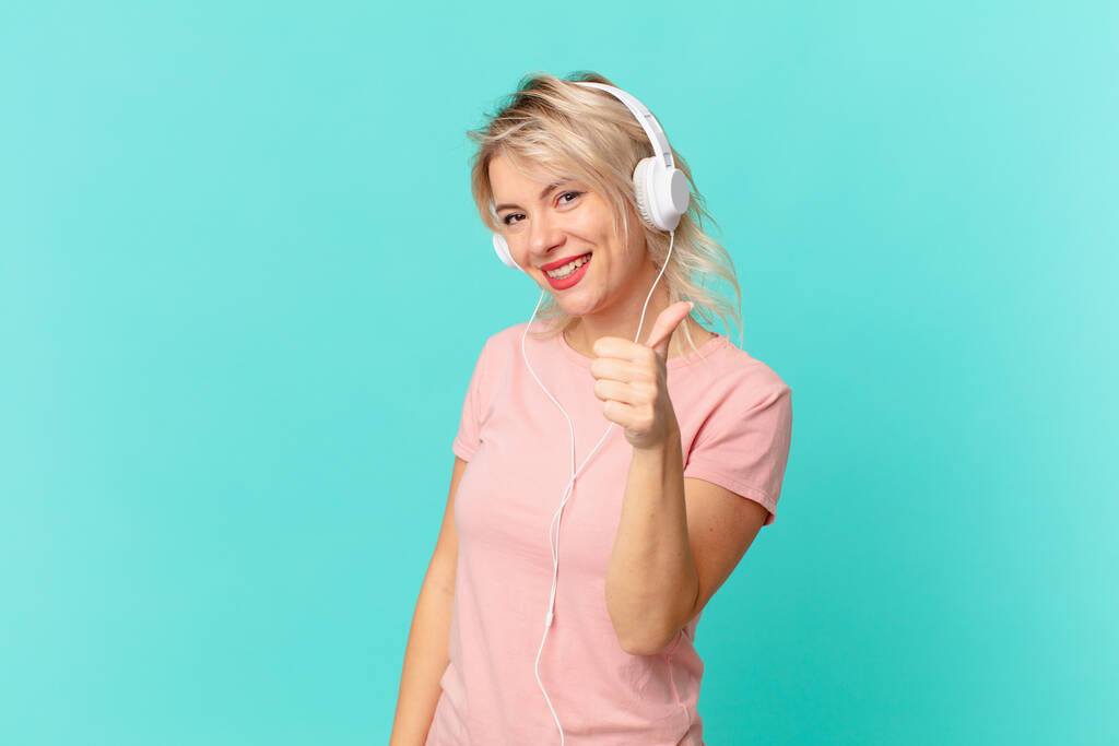 young pretty woman feeling proud,smiling positively with thumbs up. listening music concept - Foto, Imagen