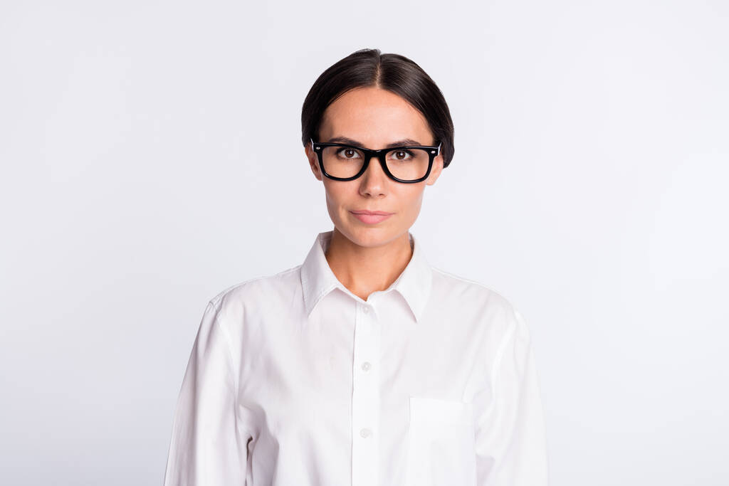 Zdjęcie optymistycznej brunetka fryzjerka pani nosić okulary biała koszula izolowane na szarym tle koloru - Zdjęcie, obraz