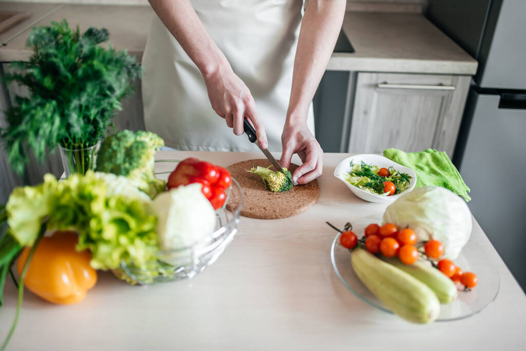 mannelijke handen hakken salade en ui, koken gezond voedsel in de keuken. - Foto, afbeelding