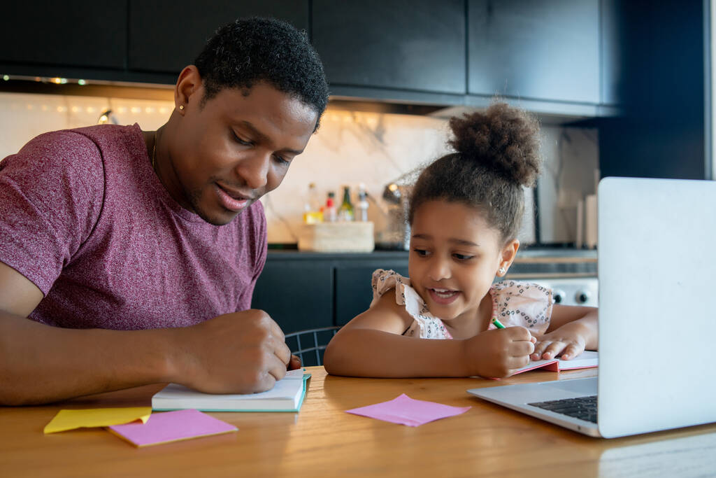 Ein Vater hilft seiner Tochter bei den Hausaufgaben. - Foto, Bild