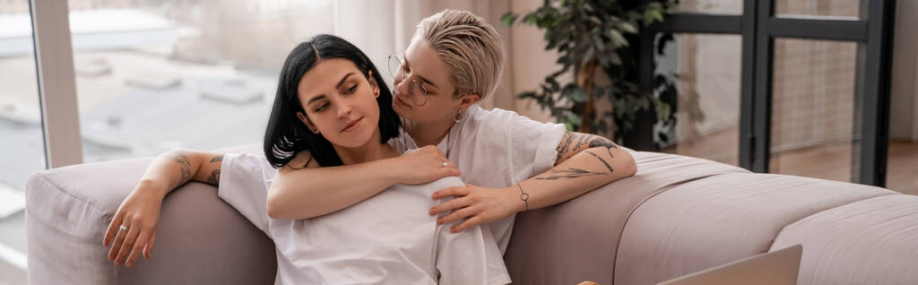 joven lesbiana pareja chilling en sofá, banner - Foto, imagen