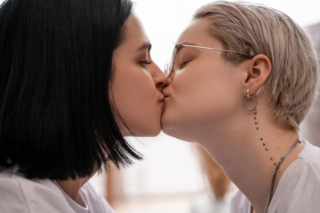вид збоку любляча лесбіянка пара цілується вдома
 - Фото, зображення