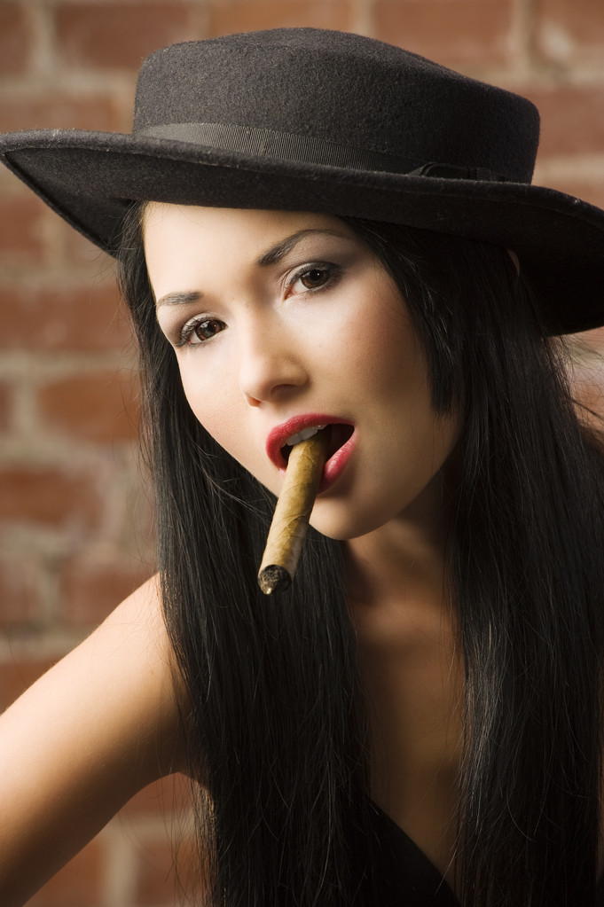 molto carino asiatico ragazza con un nero cappello fumare un sigaro
 - Foto, immagini