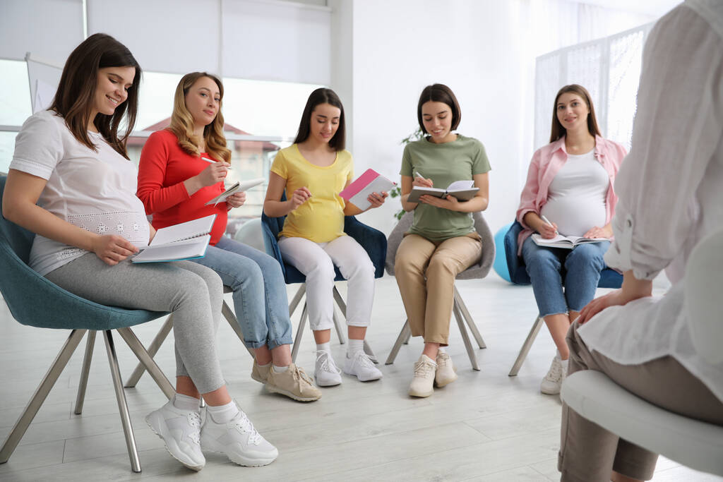 Grupa kobiet w ciąży z położną na kursach dla kobiet w ciąży w pomieszczeniach - Zdjęcie, obraz